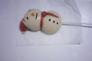 在雪人底部插上纸棒。再把雪人的手臂插上即可