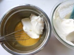 冰箱取出冷藏的蛋白霜，先取一小部分蛋白霜加入到蛋黄糊中翻拌均匀
