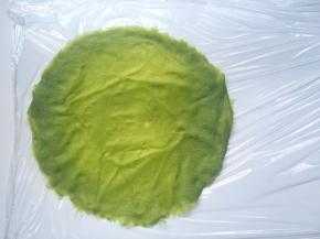 冰箱取出冷藏的面皮，面皮底下铺上油纸或保鲜膜，取一张抹茶面皮铺上
