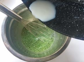 将热牛奶一点点倒入抹茶糊中，之后用蛋抽搅拌均匀
