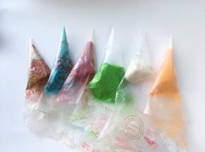 先取一小部分蛋白霜加入一点点的低筋面粉搅拌均匀，做为白雪跟雪人，剩下的蛋白霜加入一小勺蛋黄糊，分别调成4份彩色，具体颜色可以根据个人喜好来调，绿色的那一份多一些 

