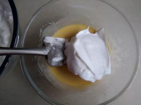 取1/3打发好的蛋白霜放入到蛋黄糊里，从上往下切拌均匀