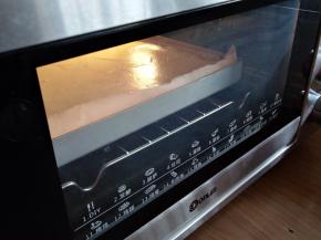 倒入铺了油纸的正方形金色烤盘里，在桌面上震几下，震出气泡。放入已经预热好上火170度，下火175度的东菱K40C烤箱中下层，烘烤18分钟左右