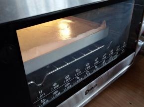 倒入铺了油纸的正方形金色烤盘里，在桌面上震几下，震出气泡。放入已经预热好上火170度，下火175度的东菱K40C烤箱中下层，烘烤18分钟左右