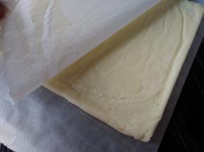 烘烤好的蛋糕立即取出，晾3分钟后倒扣在另一张干净的油纸上，趁热撕去底部的油纸，放凉