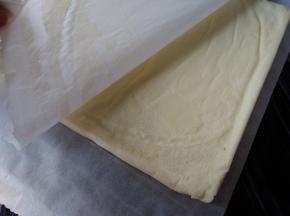 烘烤好的蛋糕立即取出，晾3分钟后倒扣在另一张干净的油纸上，趁热撕去底部的油纸，放凉