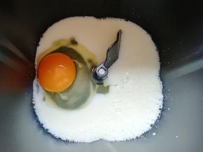 纯牛奶倒入面包机桶内，打入鸡蛋。