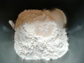 加入高筋面粉，细砂糖放在一边，面粉中间挖个小洞放入干酵母。