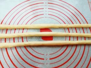 先取三份面团，搓成60-70厘米的长条状。