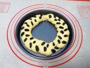 发酵完成以后取出花环面包，刷上一层蛋液，放上黑加仑葡萄干。
烤箱上下管170度预热。