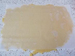 准备好油纸，铺在台面上，放上变硬的面团压扁，上面再盖上一张油纸，擀至3mm厚度即可。