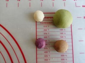 分割出27克的白面团加适量的菠菜粉，揉成绿色面团。9克白面团加可可粉，揉成棕色面团。4克白面团加紫薯粉，揉成紫色面团。用搓洗衣服的手法，使蔬果粉揉合进去，如果太难揉的话，可以加几滴水再揉