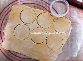 松弛好的面团擀开擀簿，然后用饺子模把面皮按压出来