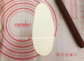 取一个小面团，把小面团擀成椭圆形，借助刮板把面团翻面