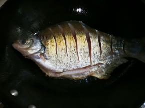 热锅热油放入鳊鱼煎至金黄