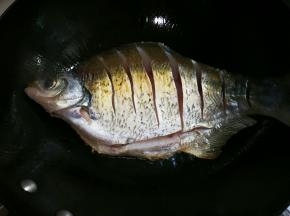 热锅热油放入鳊鱼煎至金黄
