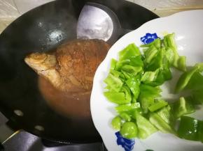 中火烧至汤汁剩下三分之一，中途翻面，放入泡椒