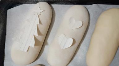 用纸剪出喜欢的图案，放在面包上，再筛少许高筋面粉。