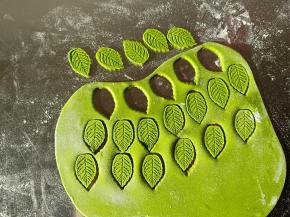 剩余的绿色面团取适量擀薄片，用叶子模具压出叶子来