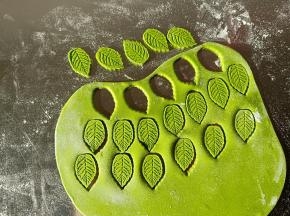 剩余的绿色面团取适量擀薄片，用叶子模具压出叶子来