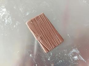 揉一个可可面团。擀薄片，用刮板压一些纹理