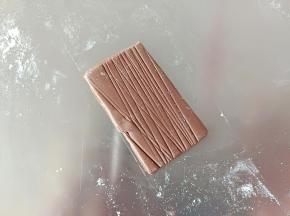 揉一个可可面团。擀薄片，用刮板压一些纹理