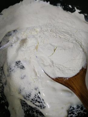 再倒入奶粉，炒拌至奶粉溶化。