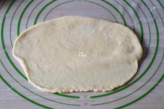 翻面后将下边沿再擀薄一点，方便收口；