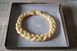 把辫子首尾相连捏紧接口，放在铺好油纸的烤盘里，另外一条也如此操作；