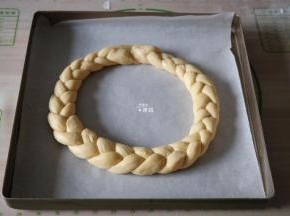 把辫子首尾相连捏紧接口，放在铺好油纸的烤盘里，另外一条也如此操作；