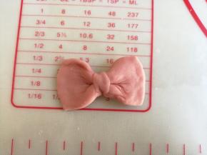 红色面团分成6份，每份都弄成蝴蝶结的样子