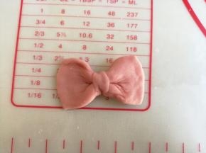 红色面团分成6份，每份都弄成蝴蝶结的样子