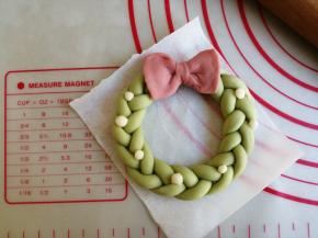 摆在花环交接处，白色面团揪出若干一丁点，装饰在花环上