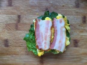 下面放一片吐司，放上一片生菜，放鸡蛋和培根