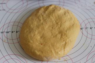 取出面团后，用手轻轻摁压排气。