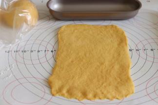 整理成和模具差不多宽度的面片，底部压薄，再卷起来，放入模具中。