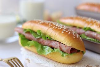 面包体腰切开，或者是顶部切开，放入蔬菜和火腿，挤上色拉酱、番茄酱，一个美味的热狗面包就完成了