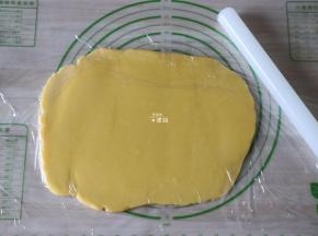 面团上下各铺一张保鲜膜，用擀面杖将面团擀成5mm左右厚的薄片；