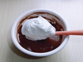 用硅胶刀取三分之的蛋白放入可可蛋黄糊容易中，翻拌均匀(切记手法，不要划算搅拌，以免消泡) 从底下往上翻拌，手法要轻。