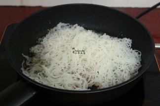 锅里留有油，大火，倒入浸泡的米粉，用筷子翻炒米粉，不能用锅铲，容易断。炒米粉一定要大火，且用筷子翻炒，米粉不会断。