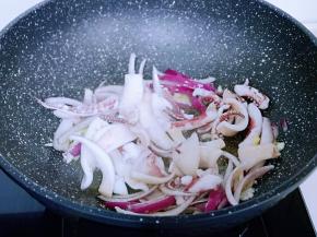洋葱炒软后再加入焯水的鱿鱼，快速翻炒。