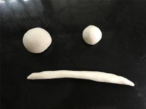 取一个白色面团，均分成二份，取其中一份再一分为二，一份搓圆用来做帽子头，一份擀成长条做帽檐。