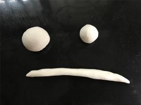 取一个白色面团，均分成二份，取其中一份再一分为二，一份搓圆用来做帽子头，一份擀成长条做帽檐。