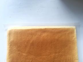 蛋糕卷下铺油纸，用锯齿刀斜着裁掉一侧的边缘，裁的时候看一下米奇的位置，别裁错边啦
