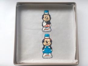 之后将烤盘入烤箱烘烤1分钟，给米奇定一下形状，烘烤后取出烤盘，放一旁降温
