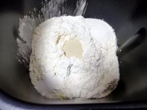 再加入高筋面粉，糖和盐对角放，发酵粉挖个小坑盖起来。启动面包机的“自动和面”程序。