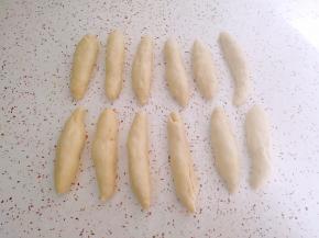 松弛好的面团按扁卷起，搓成长条状。