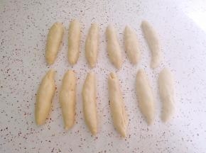 松弛好的面团按扁卷起，搓成长条状。