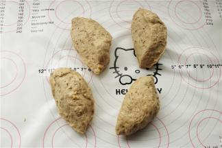 发酵好的面团，内部组织会出现细腻的孔洞，移到揉面垫上，排气后分成均匀4份，每份大约80克。