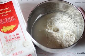 将400克金龙鱼饺子粉和150克温水揉至成干硬的面团